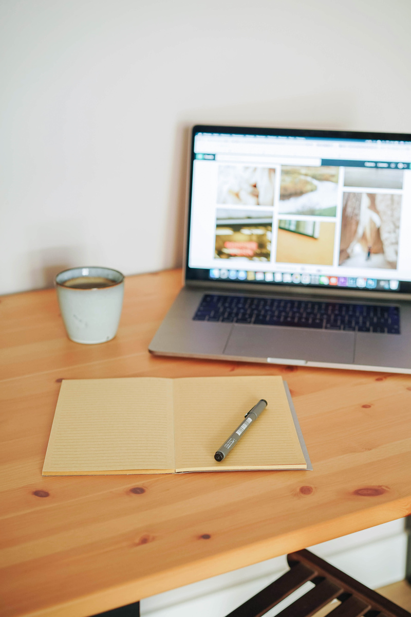 Laptop and Notebook on Wooden Desk